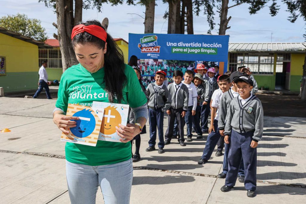 Voluntaria Iberdrola realiza juego con niñas y niños para el aprendizaje de valores, en el patio de la escuela.